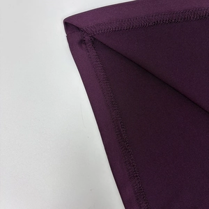 Close-up of professional purple fabric overlock stitching and high-quality seam details