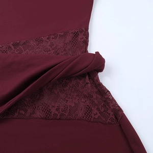 Macro view of burgundy dress detailing hollow lace pattern and knotted fabric texture