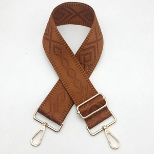Detail of dark brown geometric pattern canvas strap with gold swivel lobster hooks