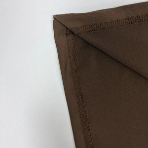 Détail du tissu froncé marron montrant les coutures de qualité et la finition plate