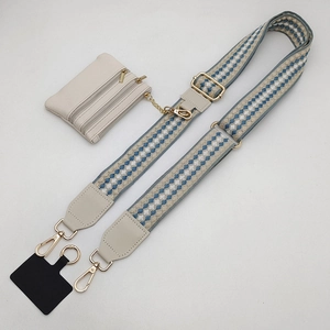 Detail view of checkered woven strap and cream leather pouch with gold hooks
