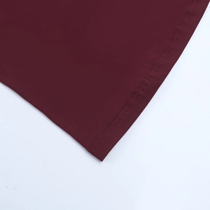 Close-up of precise stitching and hem detail on a slim-fit burgundy lace dress
