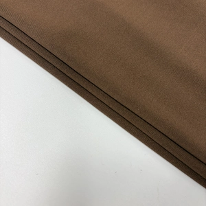 Gros plan du tissu en maille marron foncé montrant la texture d'une robe moulante