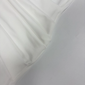 Detailed close-up showing the pleated texture of the white elegant long sleeve dress fabric