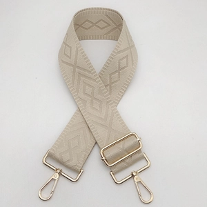 Detailed view of the 5cm wide beige woven bag strap with golden lobster clasps