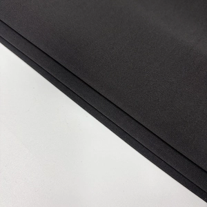 Close-up of black ribbed knit fabric showing fine texture and material detail