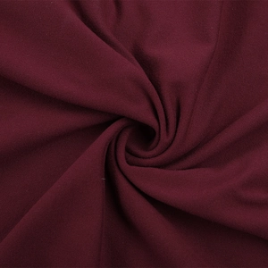 Detailed macro view of soft burgundy knit fabric texture with smooth draped folds