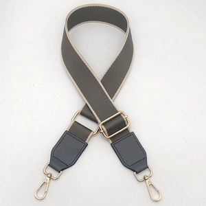 Adjustable wide canvas shoulder strap with navy leather ends and gold metal hooks