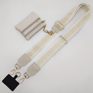 Detail of adjustable beige woven strap with zipper coin purse and gold metal hardware