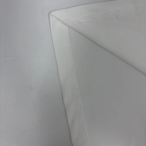 Detailed macro view of white elegant dress showing high-quality hem stitching and fabric