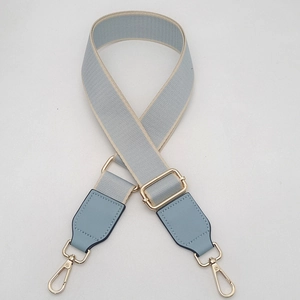 Adjustable light blue canvas bag strap with golden metal lobster clasps and leather ends