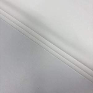 Detailed view of the soft white pleated fabric texture and elegant draping on the dress