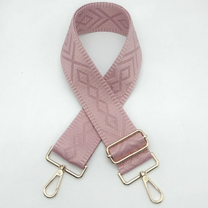 Close-up of pink geometric jacquard strap with polished light gold metal hardware clips