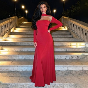 Détail d'une robe de soirée rouge longue au sol avec manches longues et col découpé