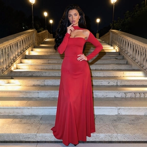Détail de l'encolure dos nu découpée sur une robe de soirée rouge à manches longues
