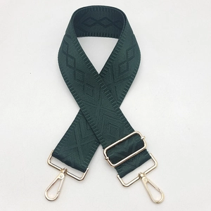 Detail of adjustable dark green geometric canvas bag strap with gold metal lobster clasps