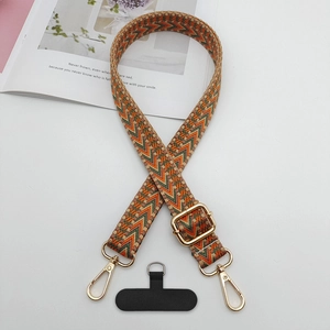 Détail de la bandoulière bohème tissée avec crochets dorés et attache téléphone