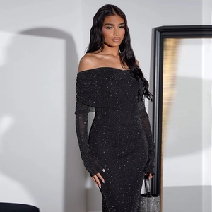 Detail of elegant black off-shoulder dress featuring shimmering silver glitter fabric texture