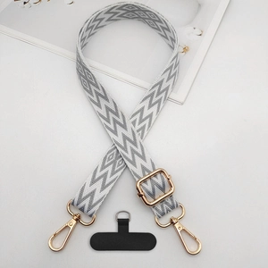 Detail view of woven phone strap with lightning jacquard pattern and gold metal hardware
