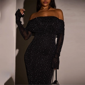 Close-up of black mesh fabric with sparkling silver sequins and stars on a slim dress