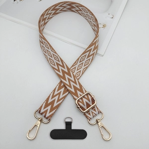 Adjustable brown and white geometric pattern crossbody strap with gold metal hooks and tab