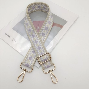 Detail of adjustable wide woven shoulder strap with light purple and beige rhombus pattern