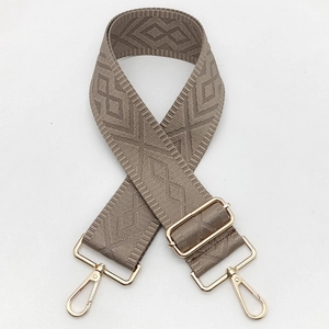Macro detail of 5cm wide adjustable canvas strap with rhombus embroidery and gold hardware