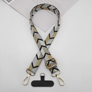 Close-up of geometric V-pattern woven strap with golden metal hardware and phone patch