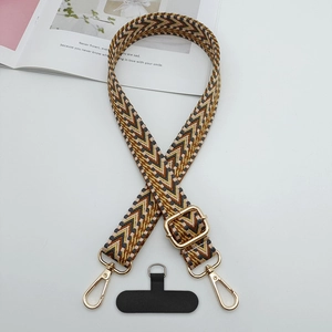 Détail de la bandoulière de téléphone jacquard tissée avec motif géométrique beige et marron