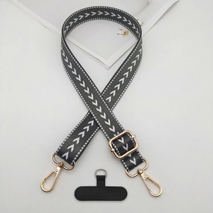 Detailed view of adjustable woven phone strap with gold metal buckles and gray pattern