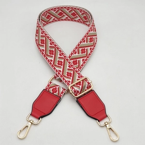 Adjustable wide jacquard bag strap with red geometric floral pattern and gold metal hooks