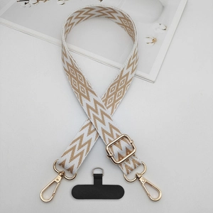 Macro shot of adjustable geometric pattern phone strap with golden metal hardware and patch