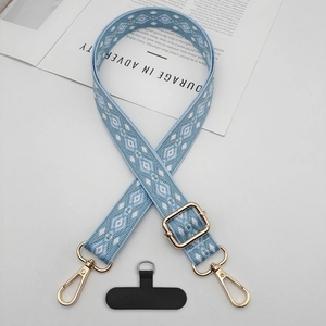 Close-up of adjustable geometric jacquard phone strap with gold hooks on a magazine