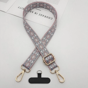 Detail of ethnic jacquard phone strap with golden clasp and black tether tab