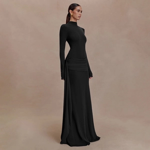 Detail of elegant black long-sleeve dress featuring waist pleats and draped side detail