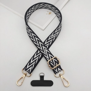 Close-up of durable black and white patterned phone strap with gold metal buckles
