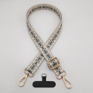 Detail of geometric woven strap with gold metal hooks and black phone tether tab