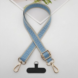 Detail view of blue geometric woven phone strap with gold hooks and adjustment buckle