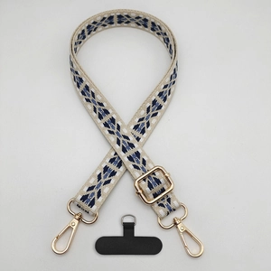 Detail of adjustable crossbody phone strap with beige and navy geometric lattice pattern