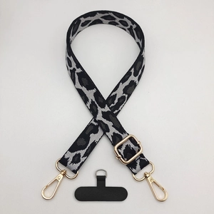 Close-up of leopard print phone strap with gold metal hooks and adjustable buckle