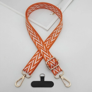 Detailed view of woven orange and white crossbody phone strap with gold lobster clasps