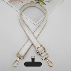 Detail of adjustable woven jacquard phone strap with geometric pattern and gold hardware