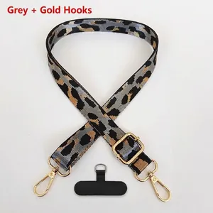Detail of adjustable leopard print polyester strap with golden metal hooks and gray pattern