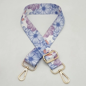 Adjustable floral pattern shoulder strap with blue and purple flowers and gold metal hooks
