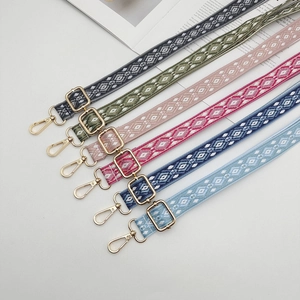 Macro detail of adjustable jacquard phone straps with geometric patterns and gold clips