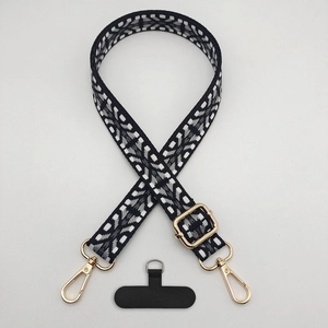 Detail of adjustable woven phone strap with vintage geometric patterns and gold metal clips