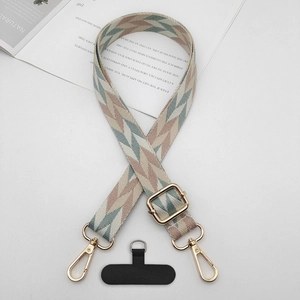 Détail d'une lanière de téléphone tissée à motif géométrique avec clips dorés