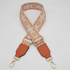 Adjustable wide replacement bag strap with orange ethnic floral pattern and gold hooks