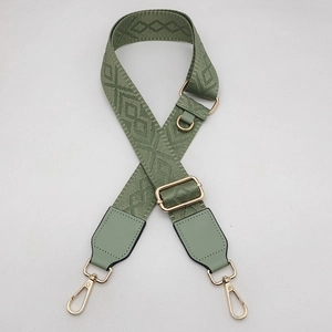 Détail de la bandoulière réglable tissée gris-vert avec motifs ethniques et clips dorés