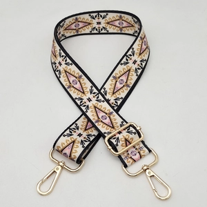 Detail of bohemian geometric print woven strap with golden swivel metal clasps
